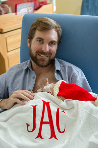 Matt holding his son at the NICU on Christmas day.